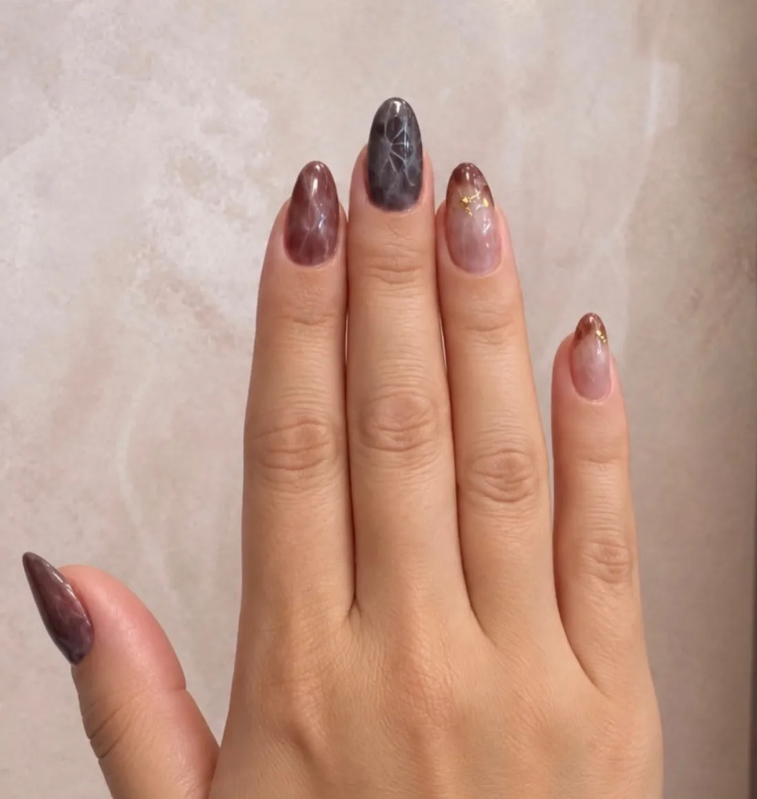 Unhas com efeito pedra e detalhes em folha de ouro