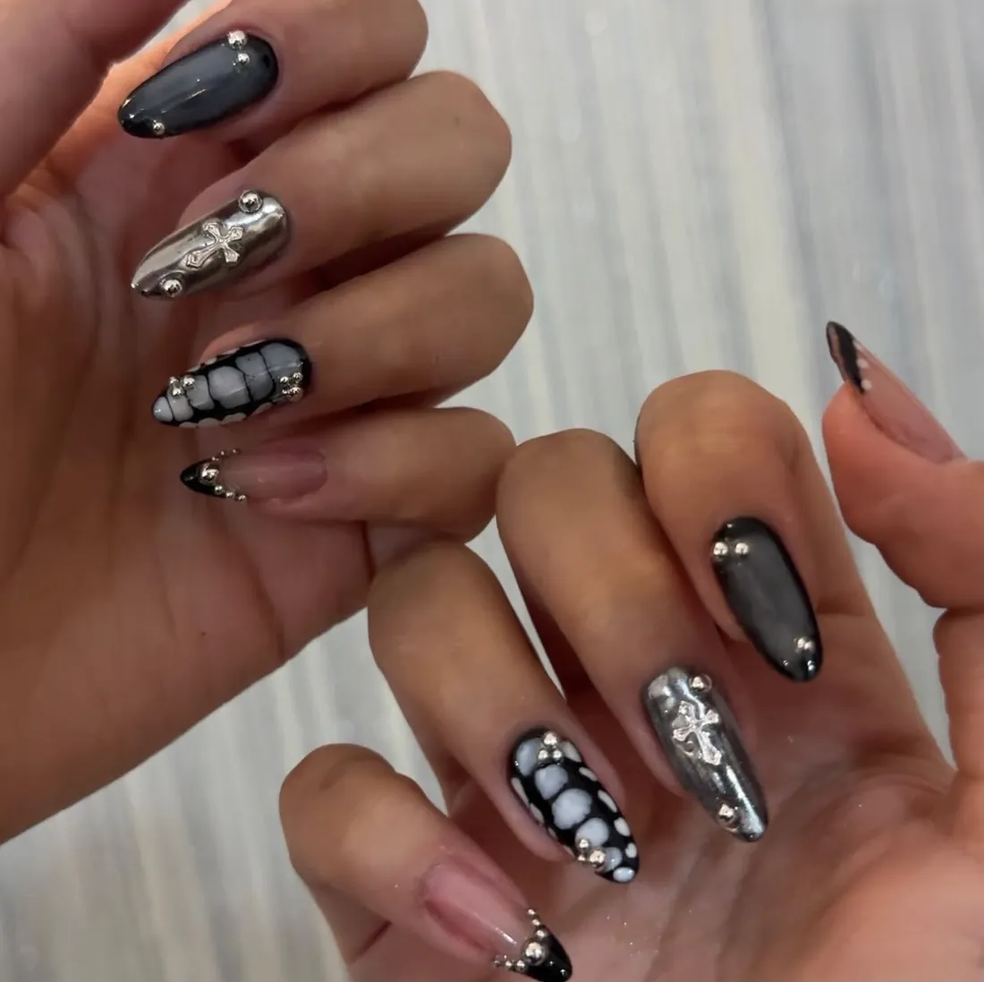 Unhas cromadas com cruzes e esferas em relevo