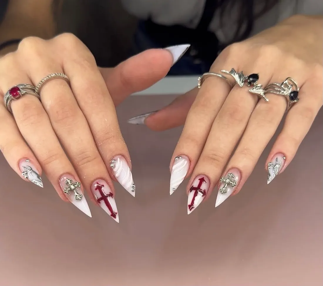 Unhas stiletto brancas com cruzes vermelhas e prateadas