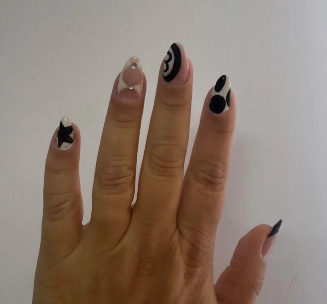 Unhas em preto e branco com estrela e círculos